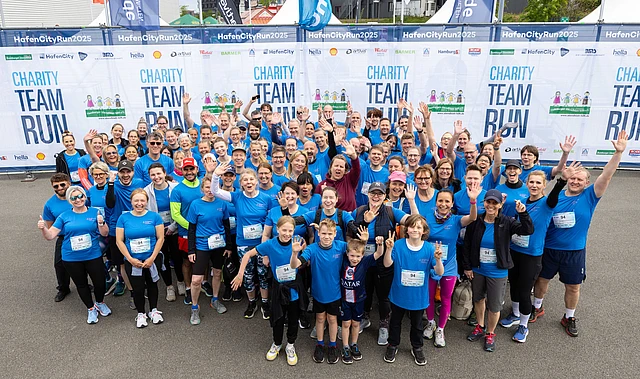 Viele Personen aus den Kirchenkreisen beim Hafencity-Run winken fröhlich in die Kamera 