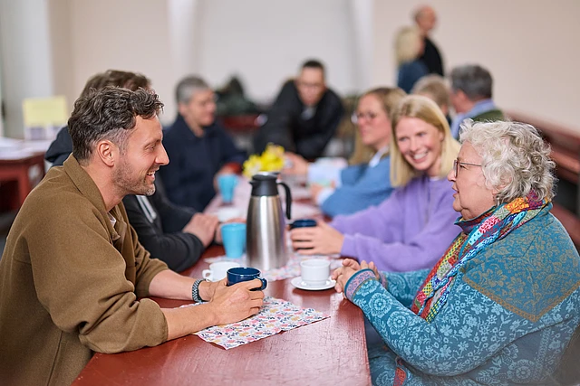 Menschen im Gespräch an einem Tisch