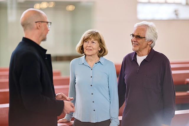 Älteres Paar im Gespräch mit Pastor in St. Trinitatis. Kirchenkreis Hamburg-West/Südholstein