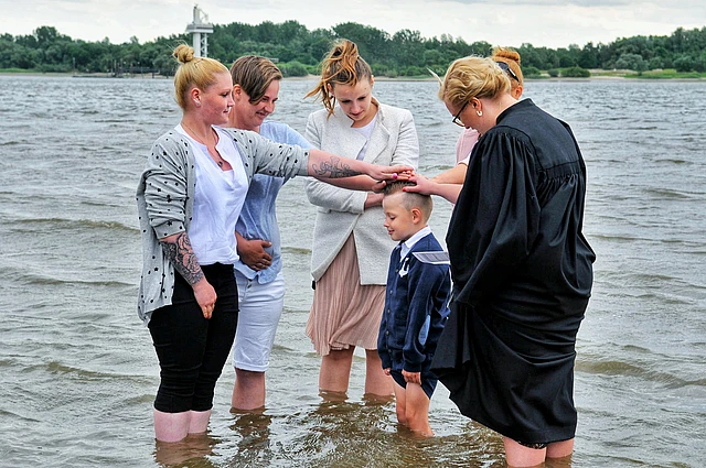 Ein Junge wird in der Elbe getauft