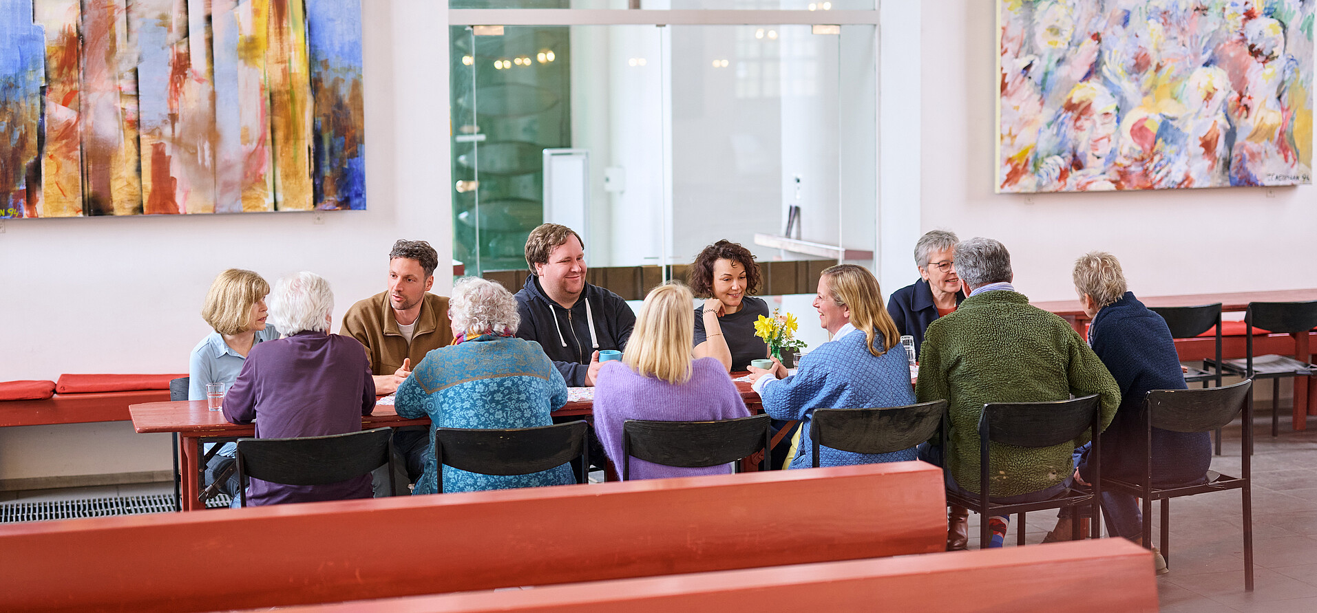 Menschen, die in Gemeinschaft am Tisch zusammen sitzen