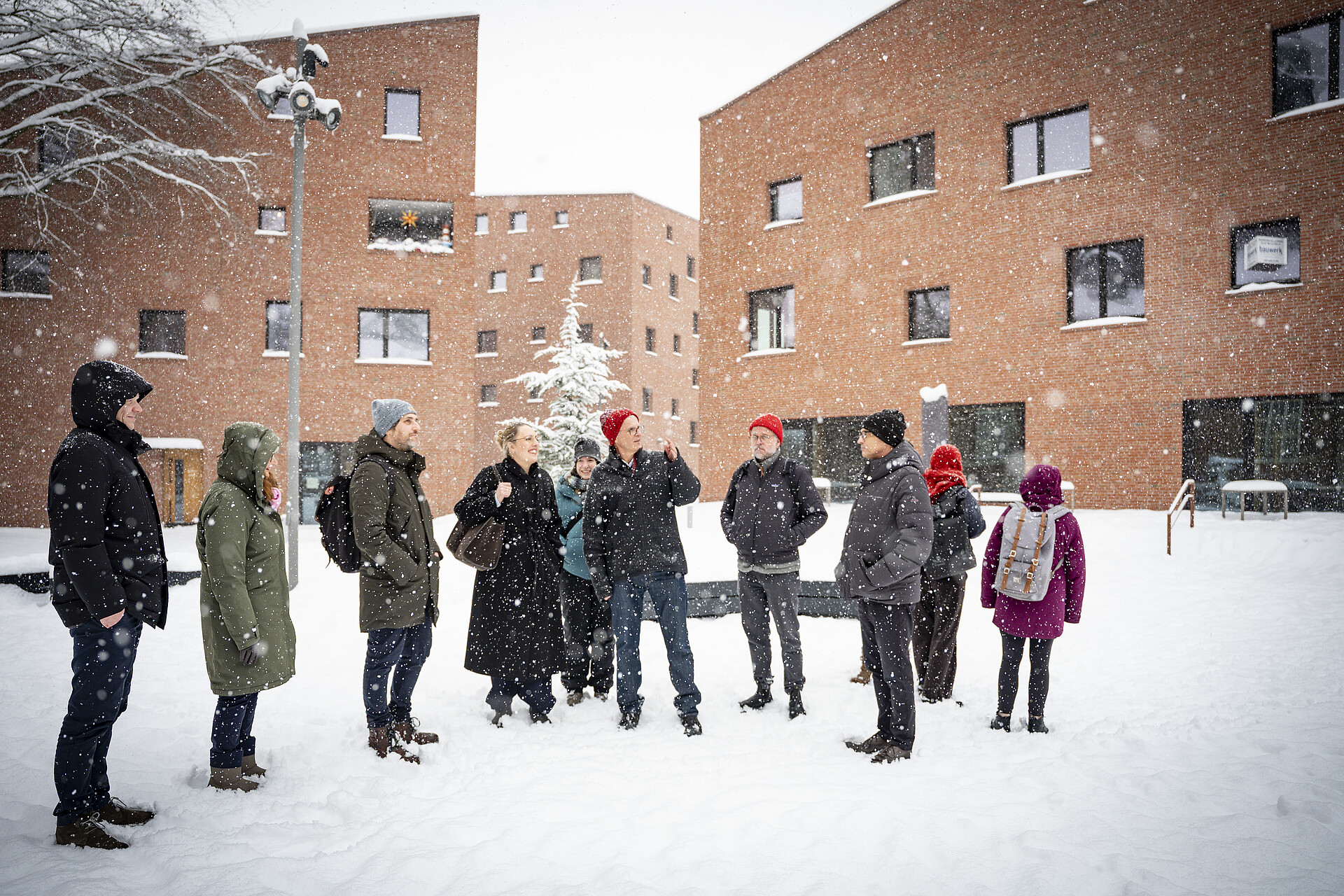Menschen im Schneegestöber bei einem Rundgang im Trinitatis Quartier