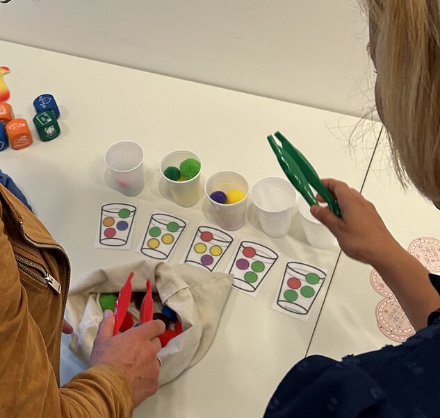 Menschen vor Schreibtisch mit Stiften und Bastelsachen